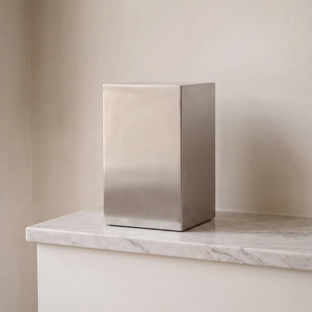 Beaumont brushed silver stainless steel urn for ashes on a white marble ledge