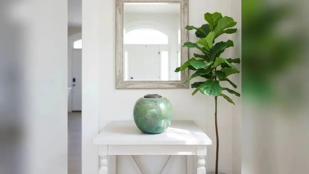 Jadeite adult cremation urn with a jade-green glaze on a hallway table