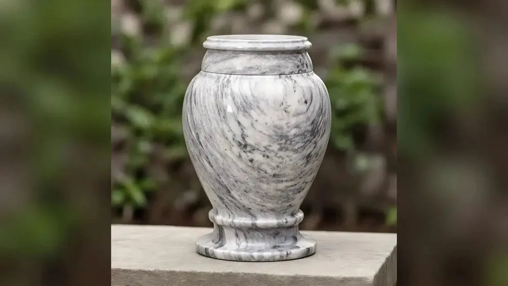 Classic Marble adult cremation urn in grey in a garden