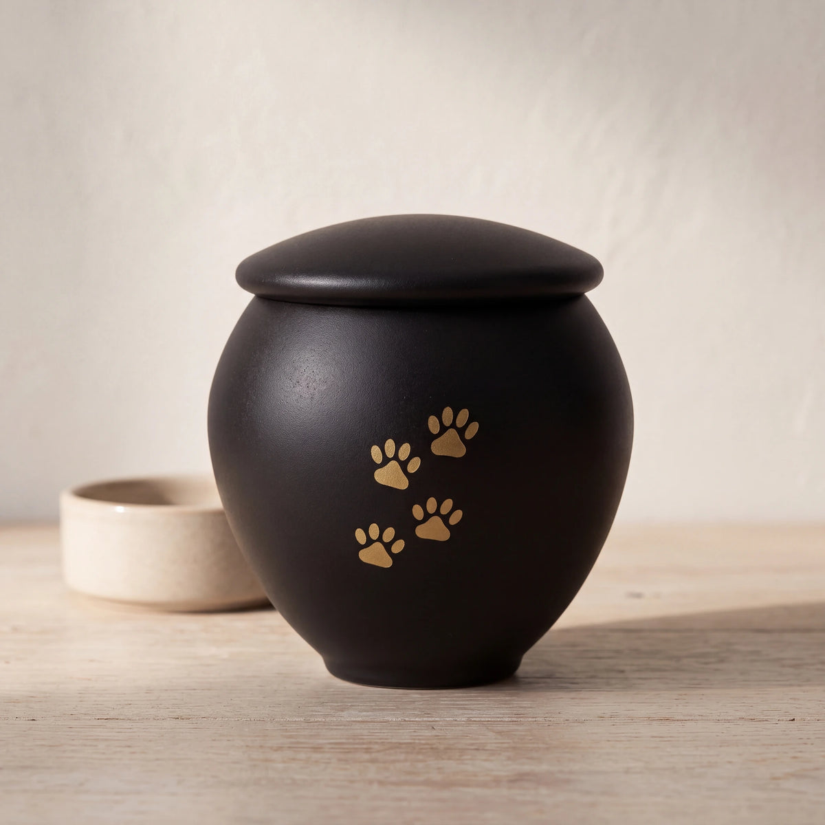 Black-Gold-Pawprints-Pet-Urn-for-Ashes-Small-pet_bowl_ledge