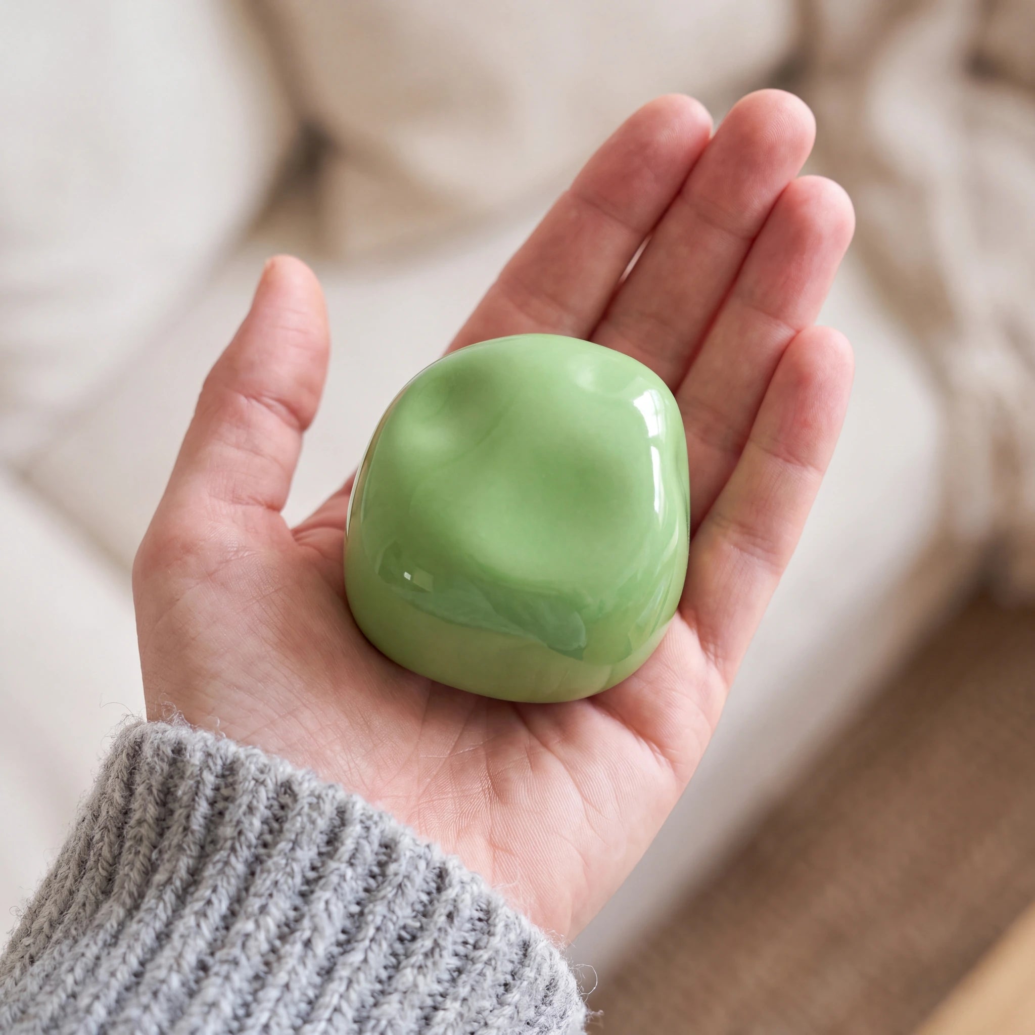 Cuddle-Stone-Keepsake-Urn-for-Ashes-in-Glossy-Apple-Green-Held-in-Palm