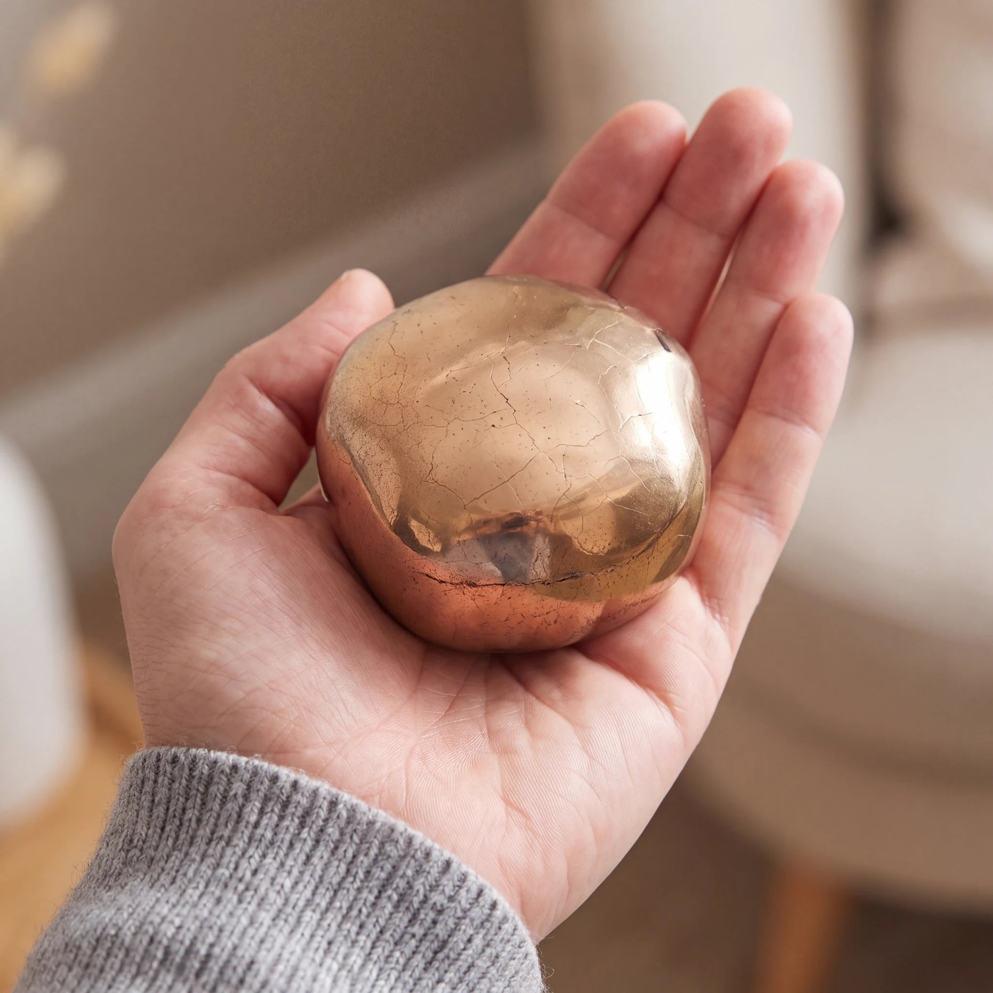 Cuddle-Stone-Keepsake-Urn-for-Ashes-in-Gold-Held-in-Palm