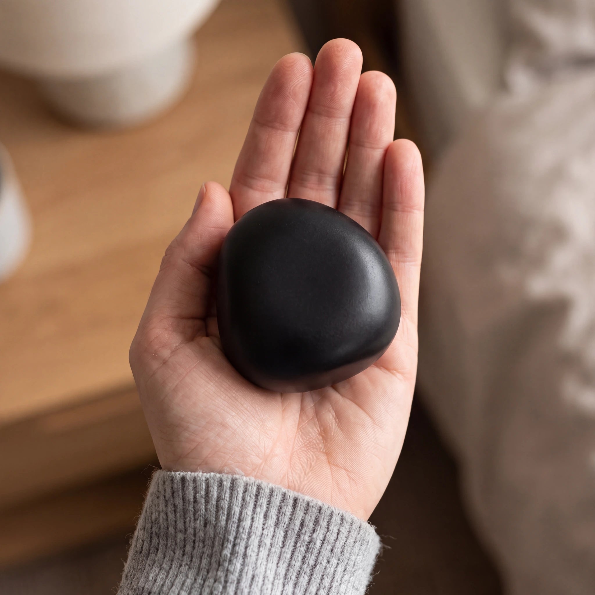 Cuddle-Stone-Keepsake-Urn-for-Ashes-in-Matte-Black-Held-in-Palm