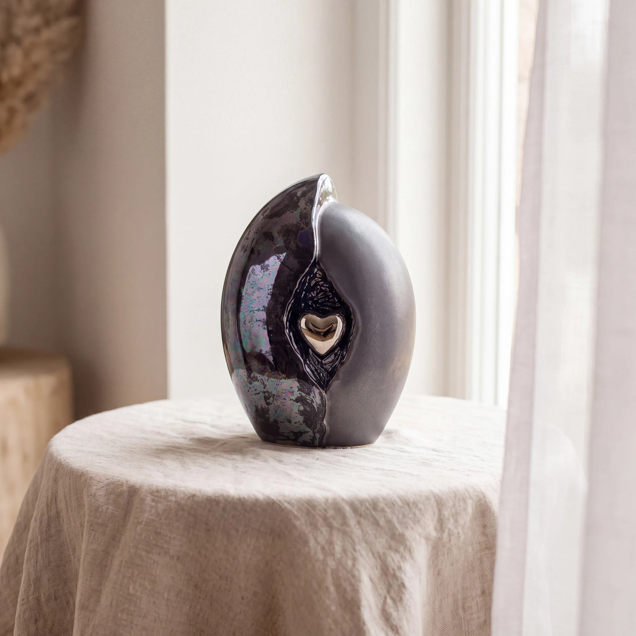 Embrace-Heart-Medium-Urn-for-Ashes-in-Dark-Blue-and-Black-Linen-Table