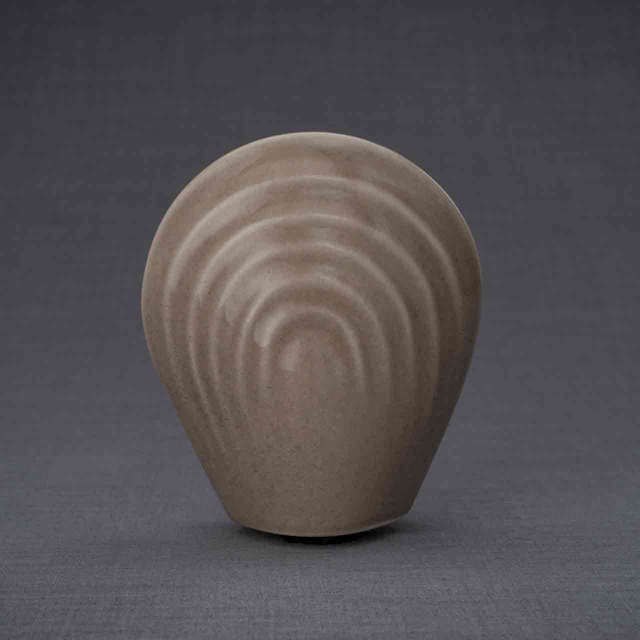 Guardian Angel Ashes Keepsake Urn in Dark Beige Behind Grey Background