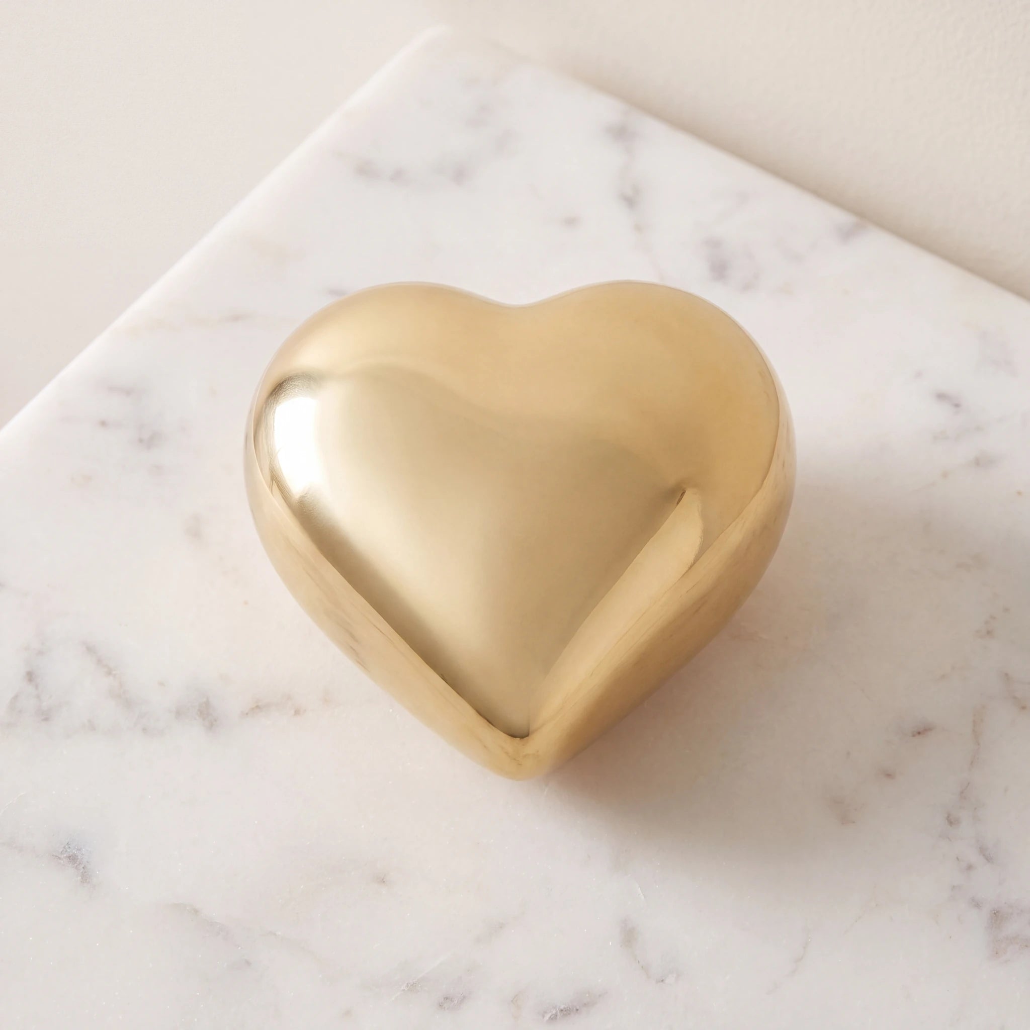 Heart-Keepsake-Urn-for-Ashes-in-Glossy-Gold-Metal-On-Marble