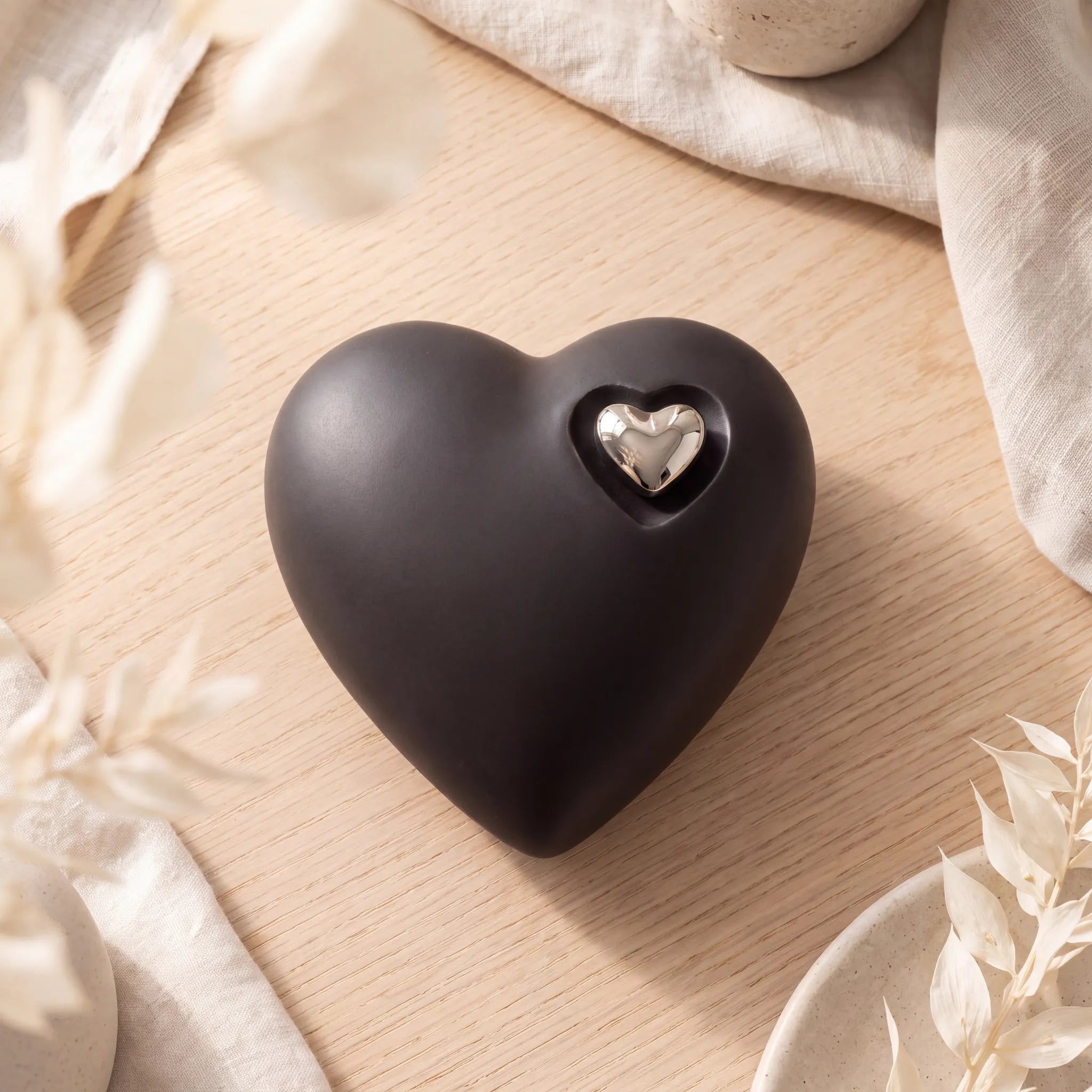 Heart-Medium-Urn-for-Ashes-in-Black-and-Silver-On-Oak