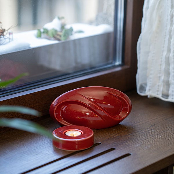 Infinity Ashes Keepsake Urn Red with Caleo Candle by Window