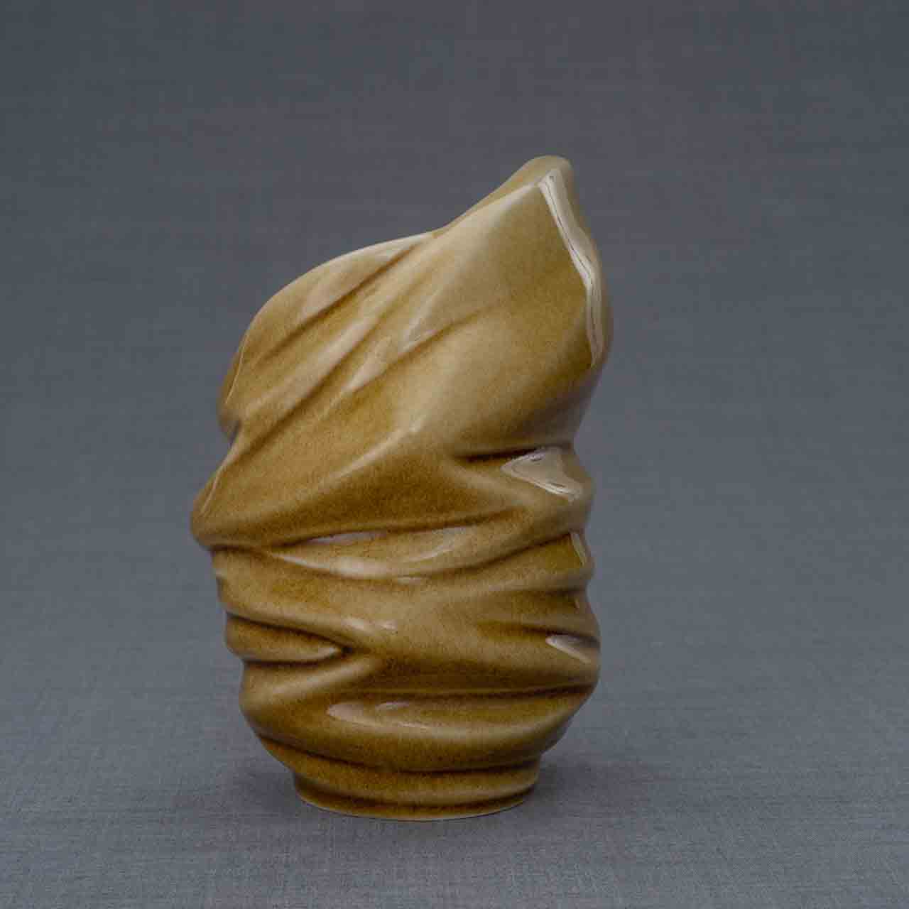 Light Ashes Keepsake Urn in Dark Sand Behind Dark Background