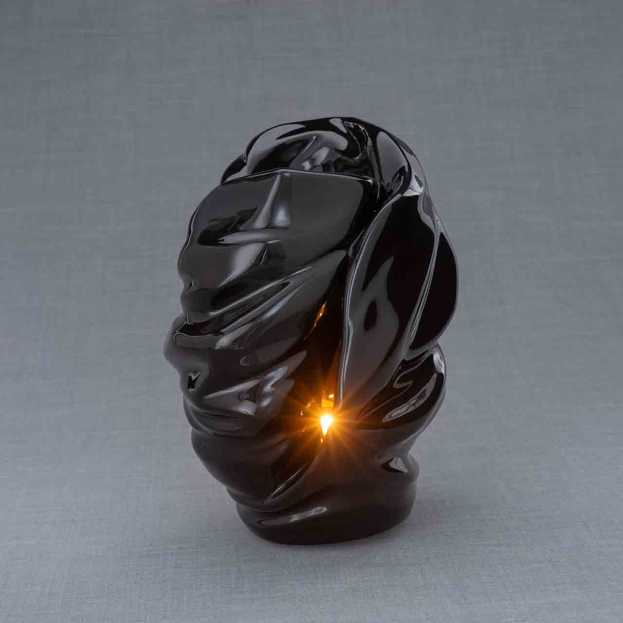 Light Cremation Urn for Ashes in Black Turned Right with Bright Candle Dark Background