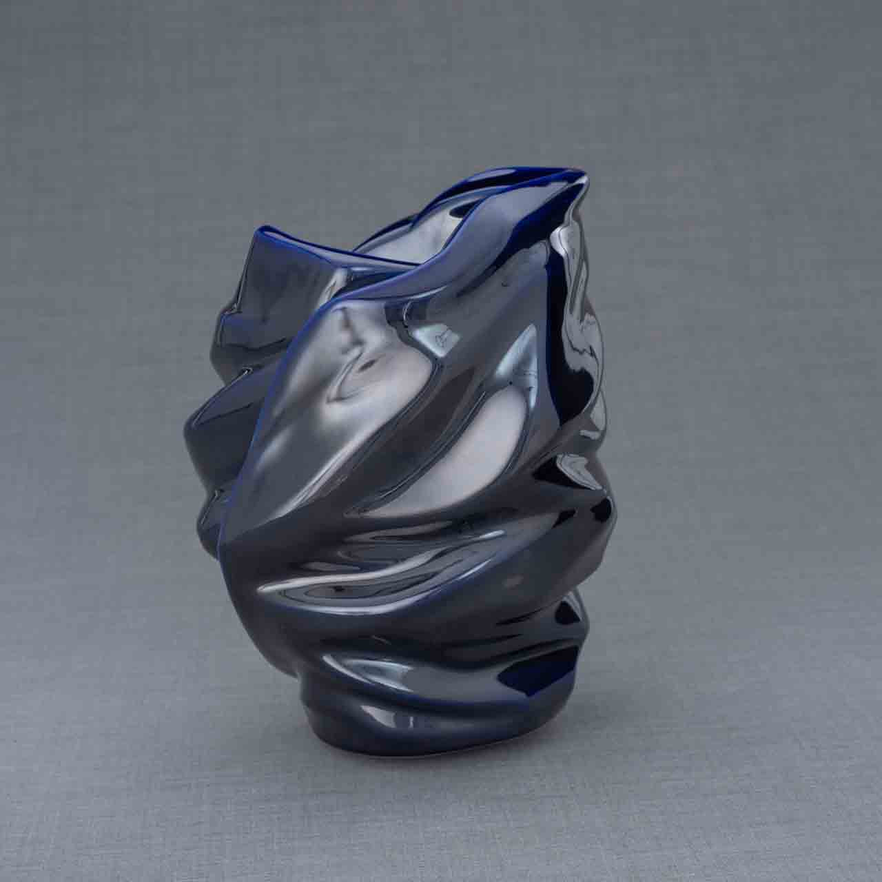 Light Cremation Urn for Ashes in Metallic Blue Behind Dark Background