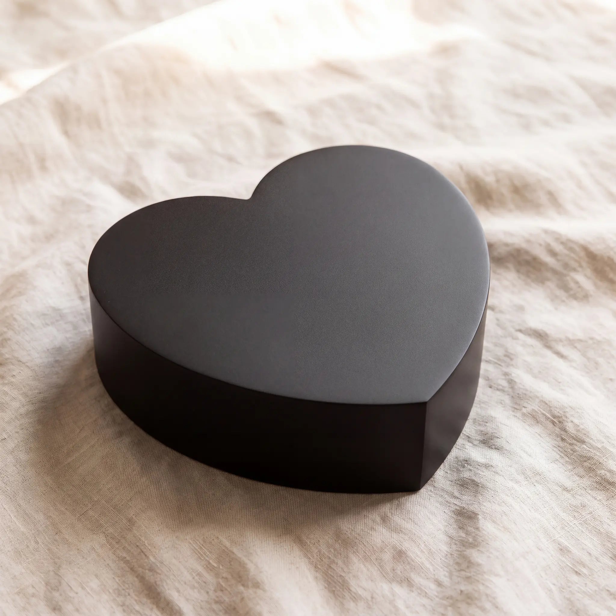 Love-Heart-Adult-Cremation-Urn-for-Ashes-in-Matte-Black-Stainless-Steel-On-Linen