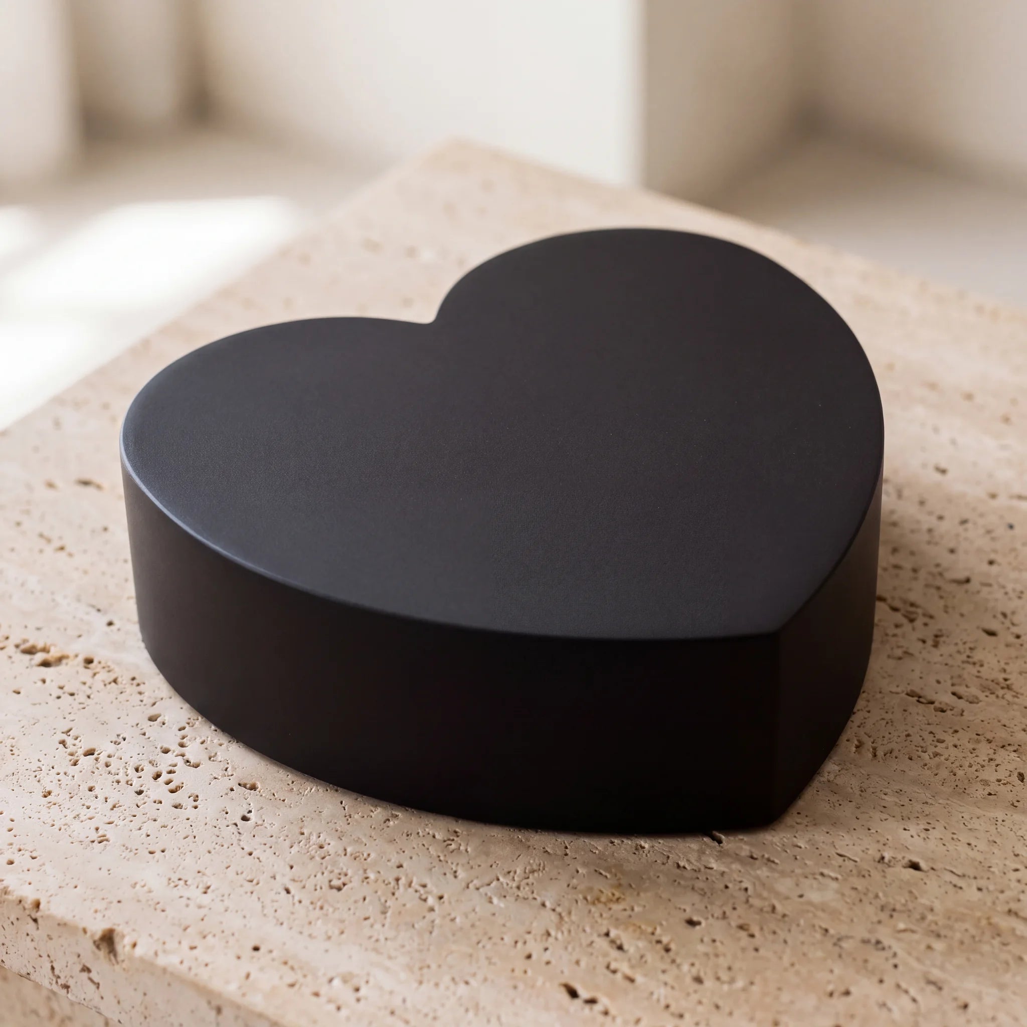 Love-Heart-Companion-Urns-for-Two-Adults-in-Matte-Black-Stainless-Steel-On-Travertine