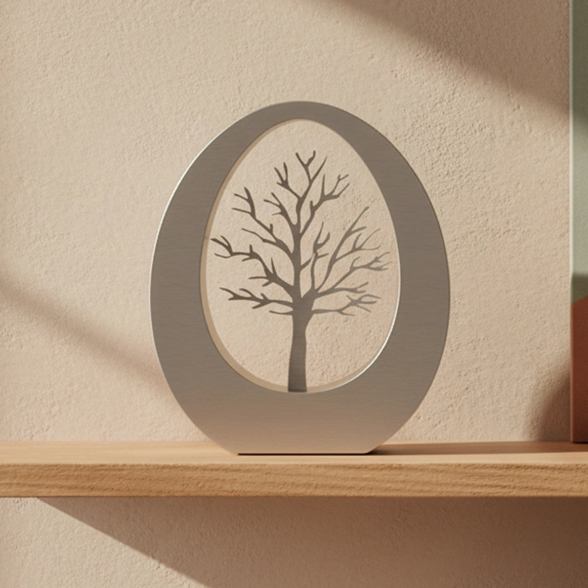 Oval Adult Cremation Urn for Ashes in Stainless Steel with Tree on Desk in Home