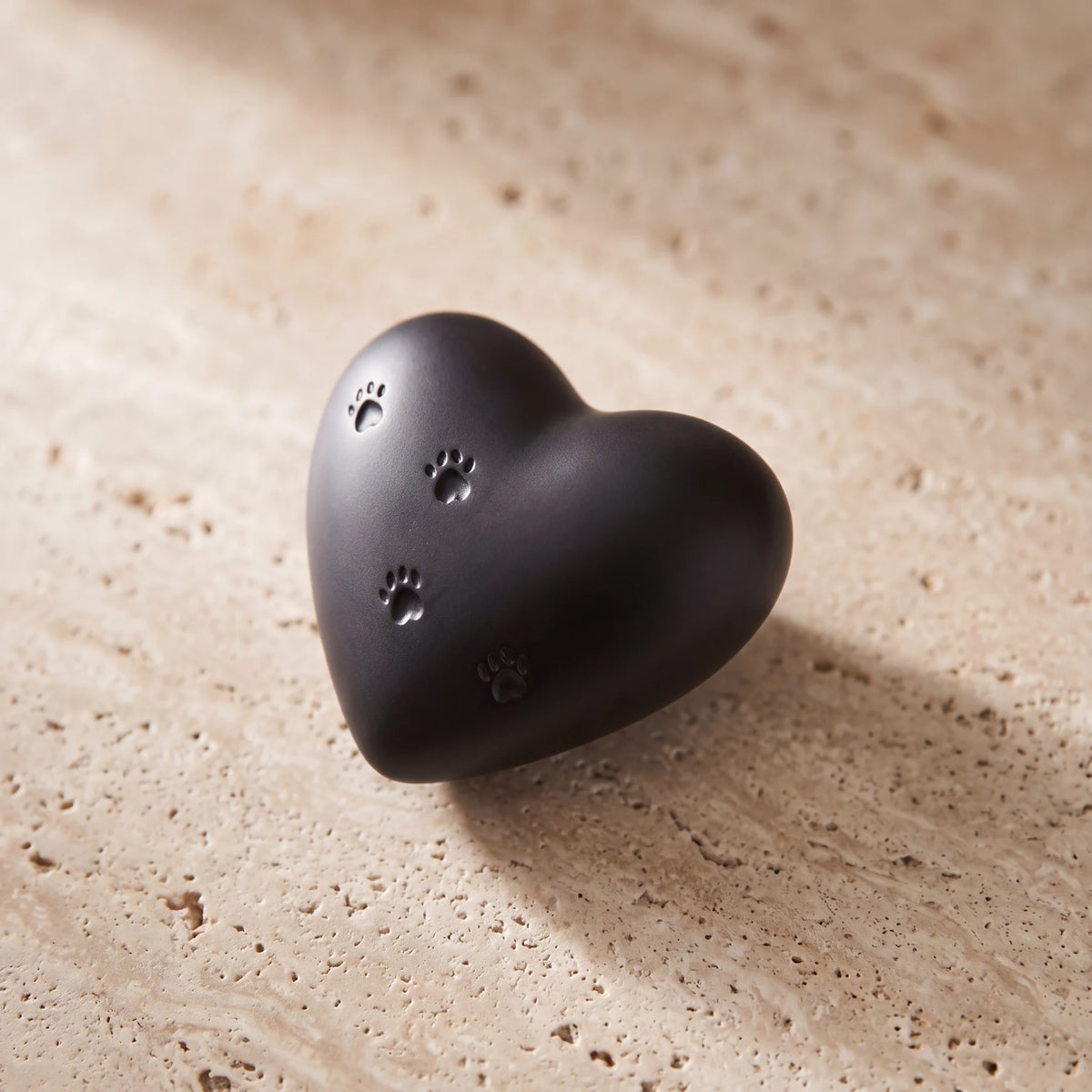 Paw-Print-Heart-Mini-Pet-Urn-for-Ashes-in-Black-On-Travertine