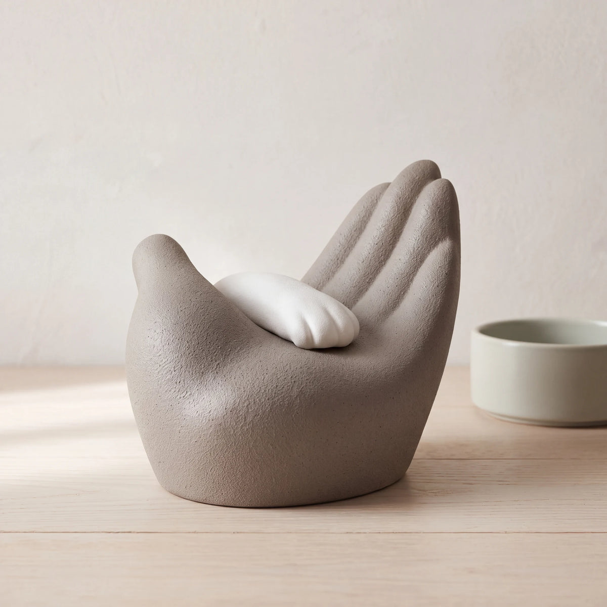 Paw-in-Hand-Pet-Urn-for-Ashes-in-Grey-White-pet_bowl_ledge
