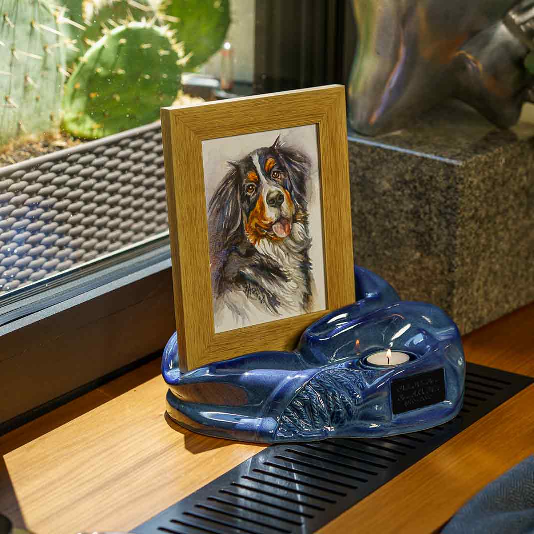 Picture Frame Pet Urns for Ashes in Blue Ceramic Facing Right with Photo of Dog on Shelf