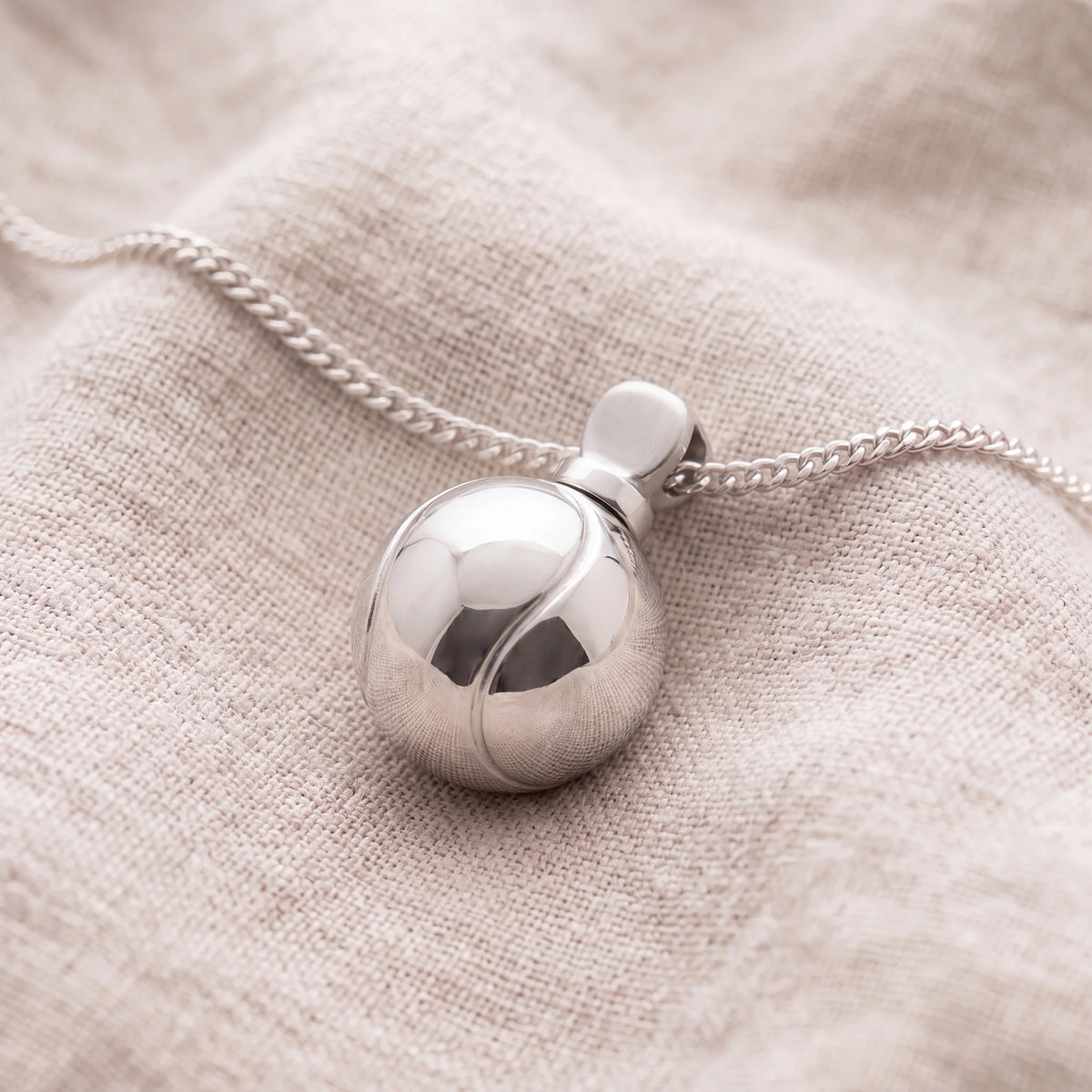 Self-fill-Tennis-Ball-Memorial-Ashes-Pendant-On-Linen