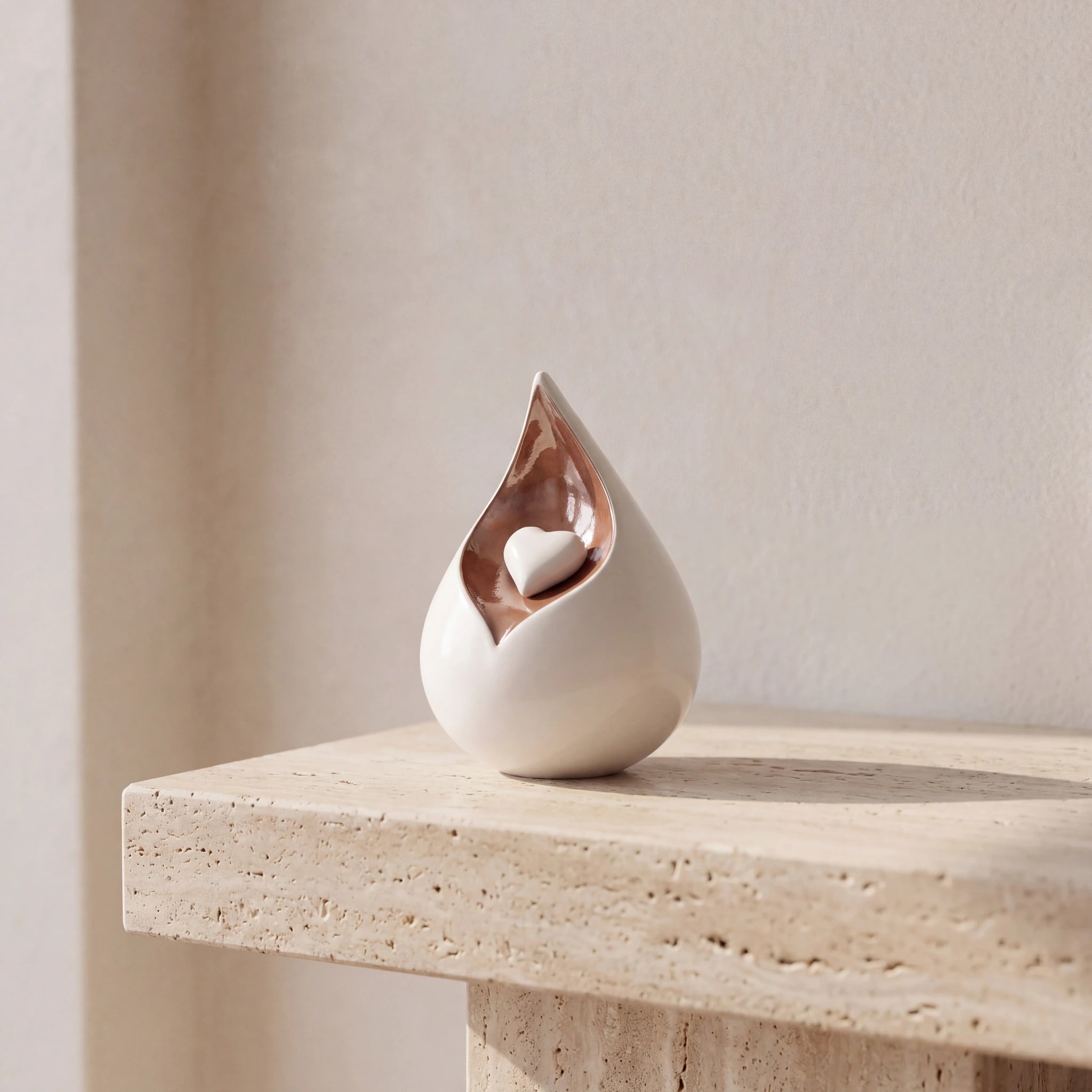 Teardrop-Medium-Urn-for-Ashes-with-Heart-in-White-and-Brown-Travertine-Ledge
