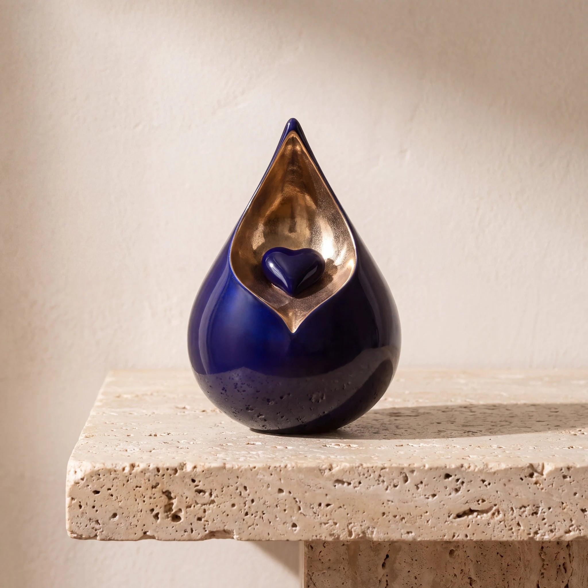 Teardrop-Small-Urn-for-with-Heart-Ashes-in-Cobalt-Blue-and-Gold-Travertine-Ledge