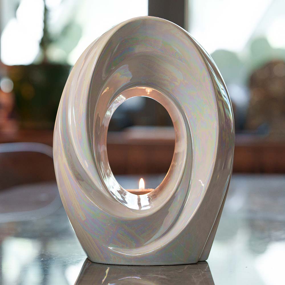 The Passage Adult Cremation Urn for Ashes in Pearlescent White On Table Front Facing Lit