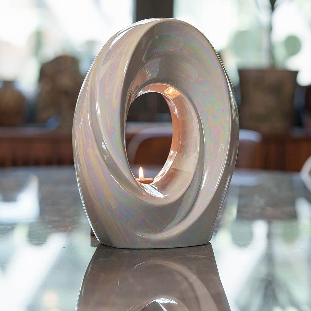 The Passage Adult Cremation Urn for Ashes in Pearlescent White on Table Facing Right