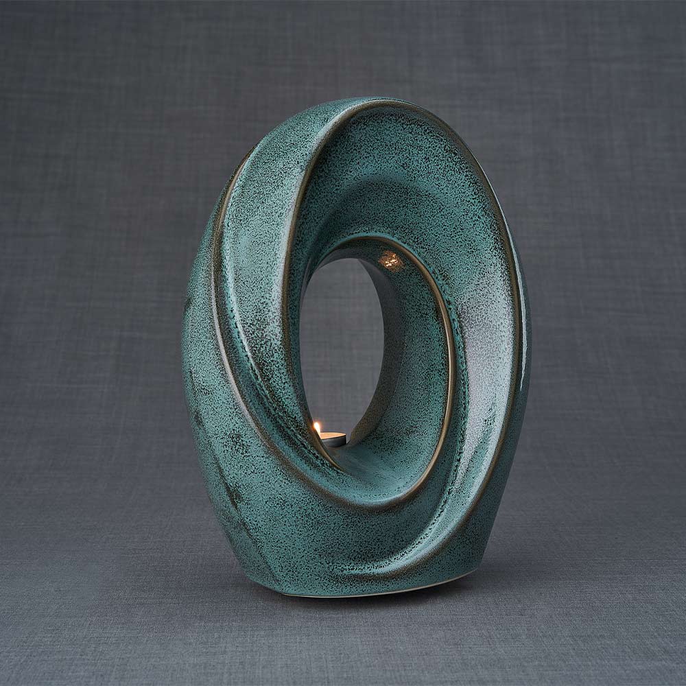 The Passage Cremation Urn for Ashes in Oily Green Facing Right Dark Background