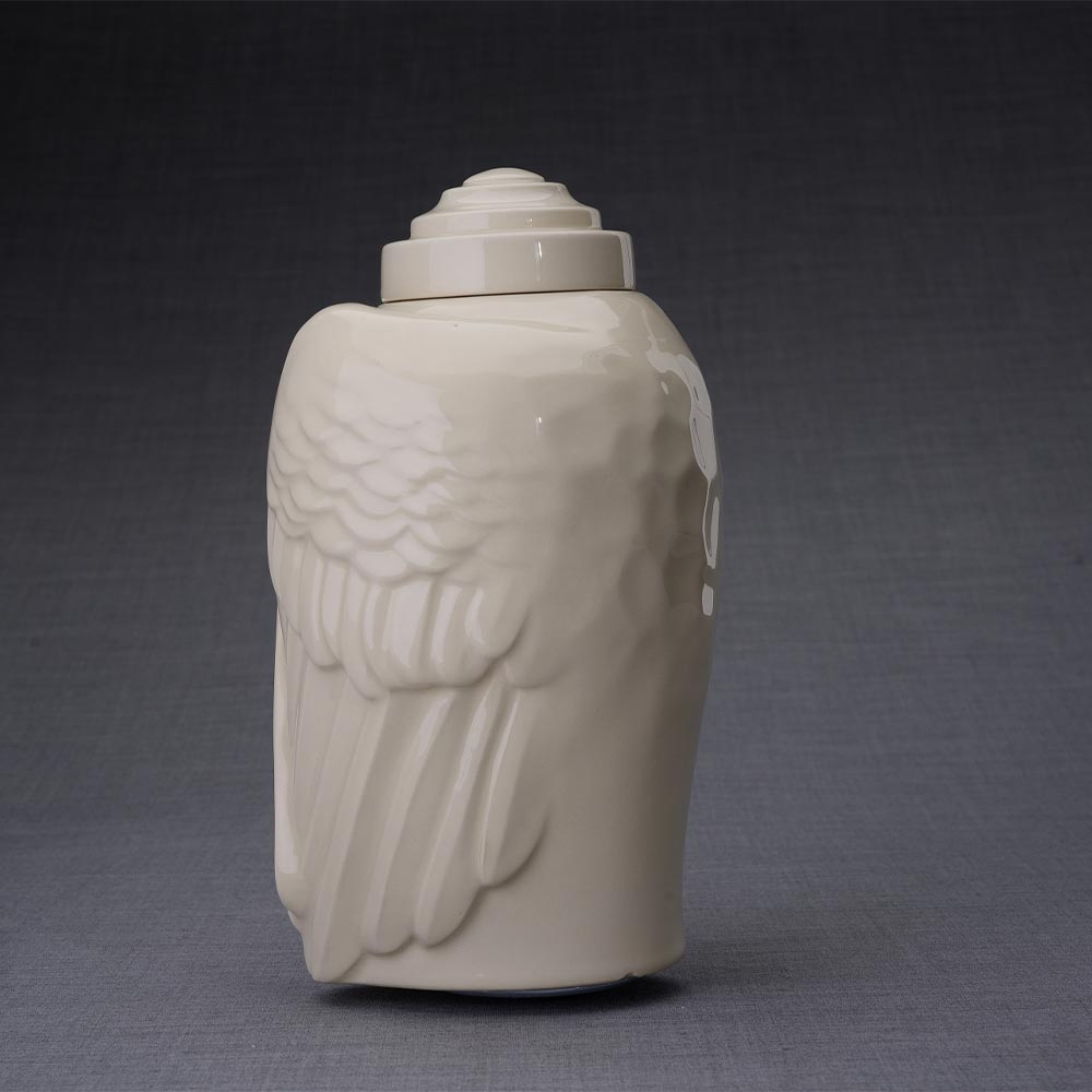 Wings Cremation Urn for Ashes in Cream Facing Left Dark Background