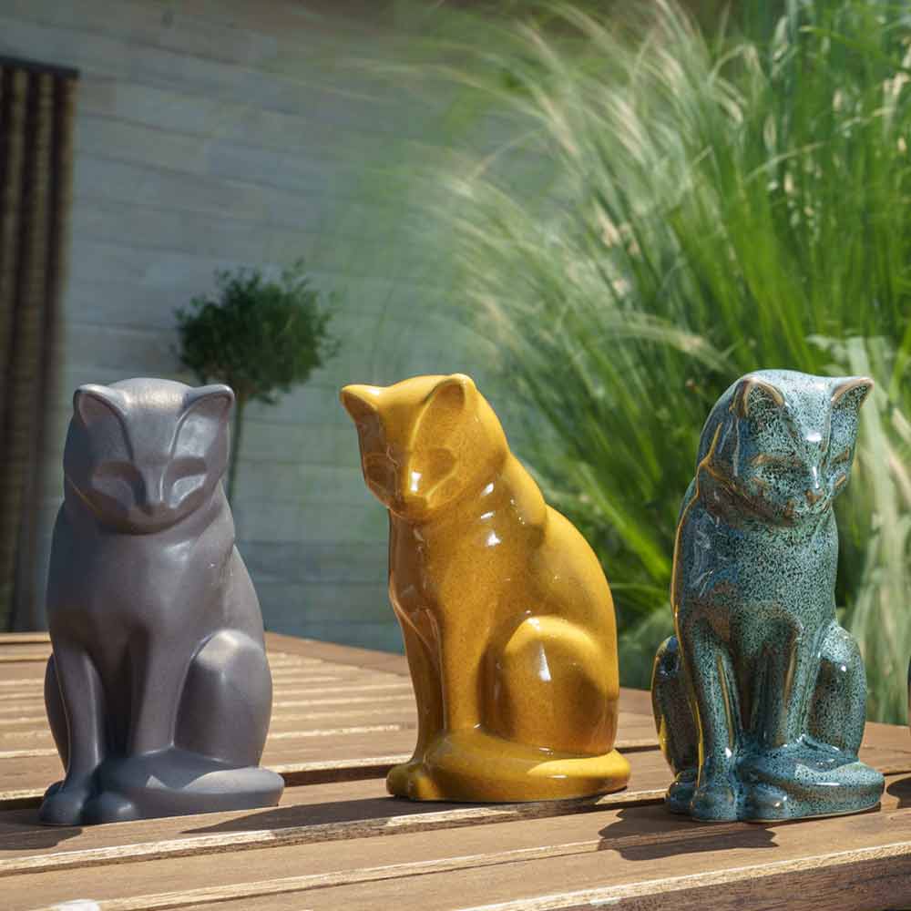 cat urns for ashes outside on table oily green matte grey