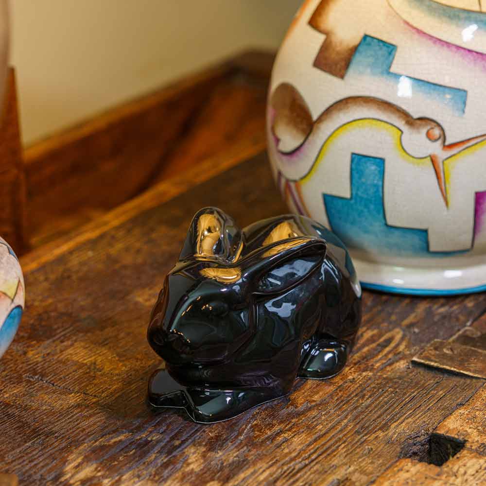 Rabbit Urn For Ashes Glossy Black On Cupboard Above Front Left