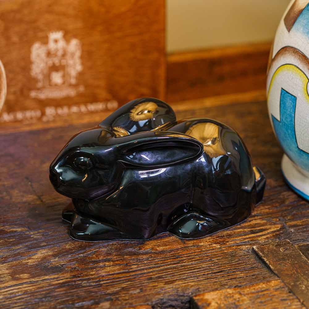 Rabbit Urn For Ashes Glossy Black On Cupboard Left Facing