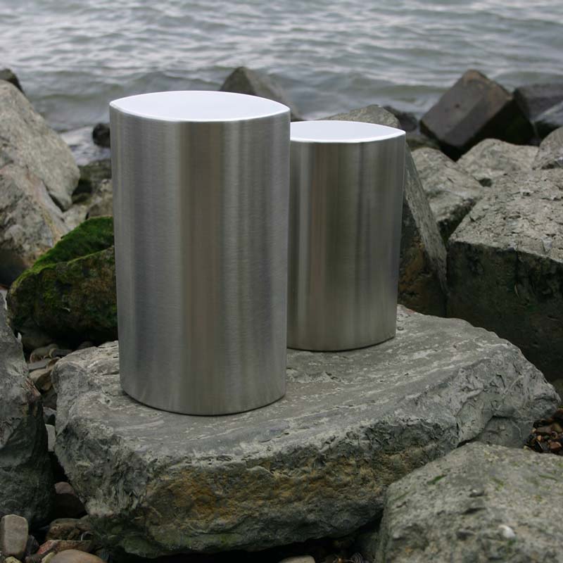 Ellipse Ashes Keepsake Urn in Stainless Steel on Rocks