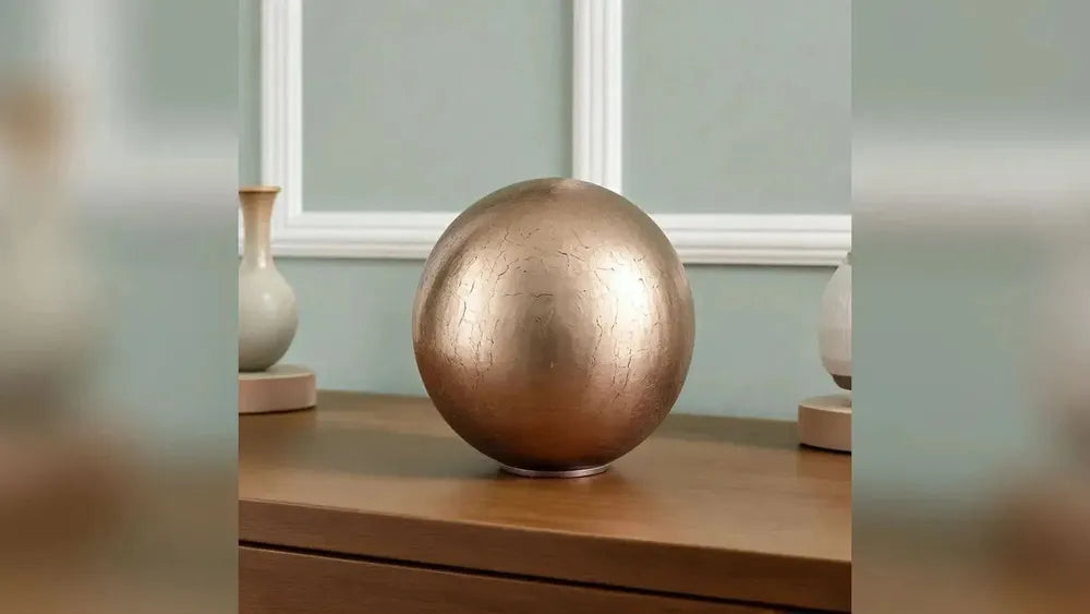 Crystal Sphere adult cremation urn in gold in a living room