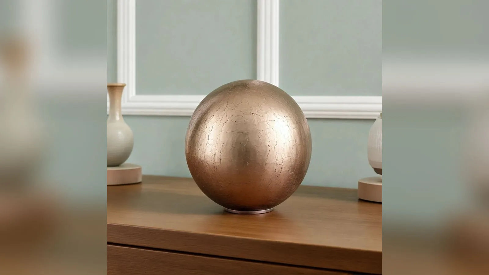 Crystal Sphere adult cremation urn in gold in a living room