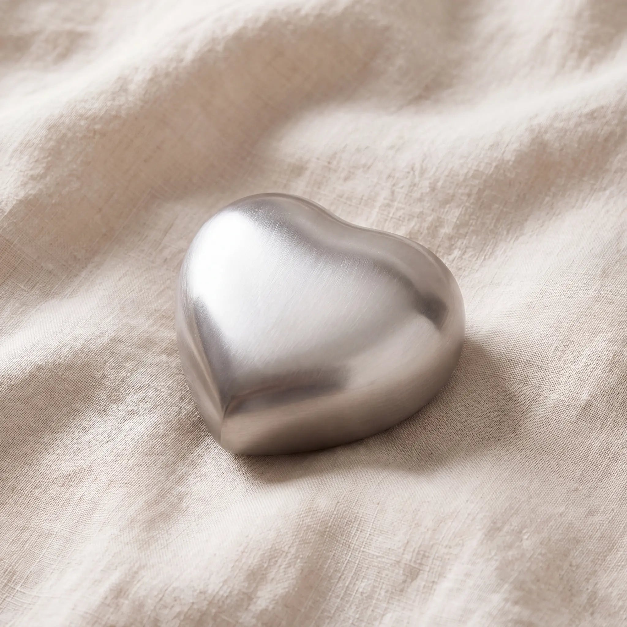 Brushed-Metal-Heart-Keepsake-Urn-for-Ashes-in-Silver-On-Linen