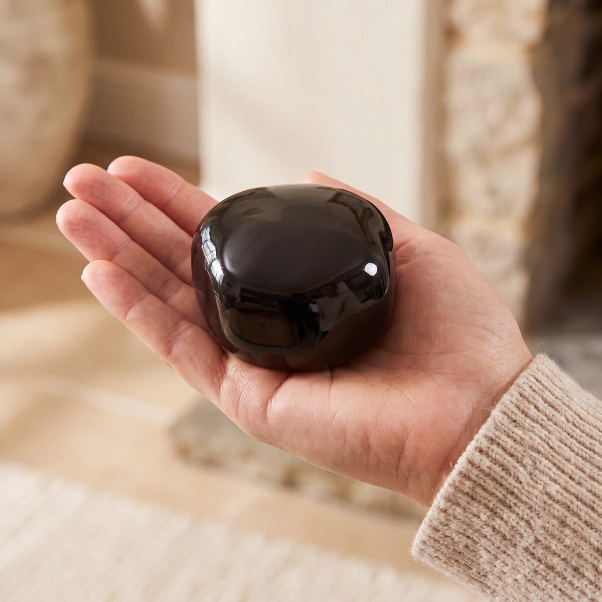 Cuddle-Stone-Keepsake-Urn-for-Ashes-in-Glossy-Black-Held-in-Palm