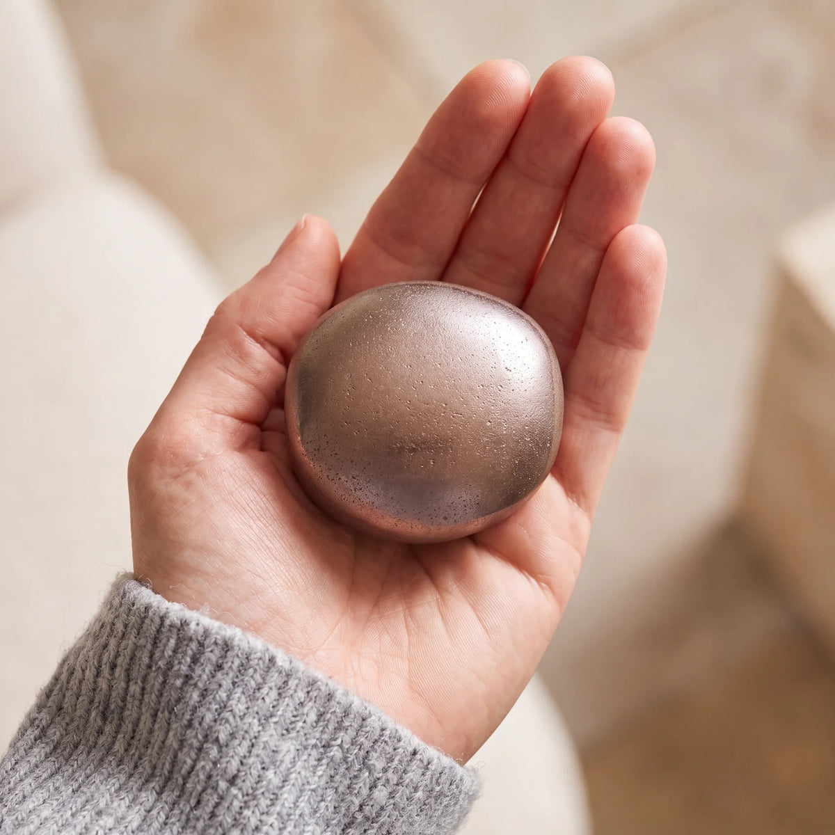 Cuddle-Stone-Keepsake-Urn-for-Ashes-in-Warm-Bronze-Held-in-Palm