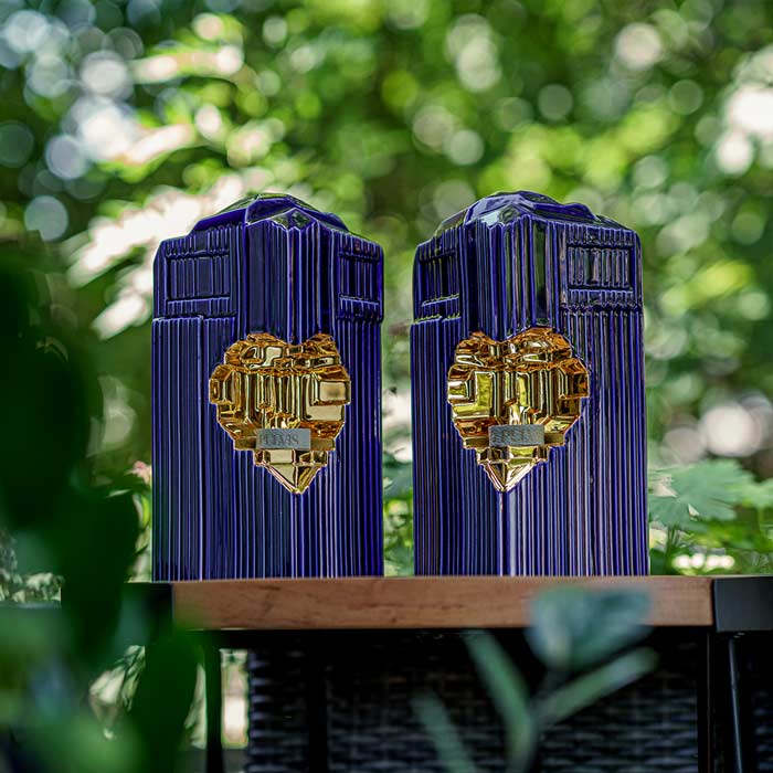 Heart Cremation Urn for Ashes Metallic Blue and Gold with Companion Outside on Table in Bushes