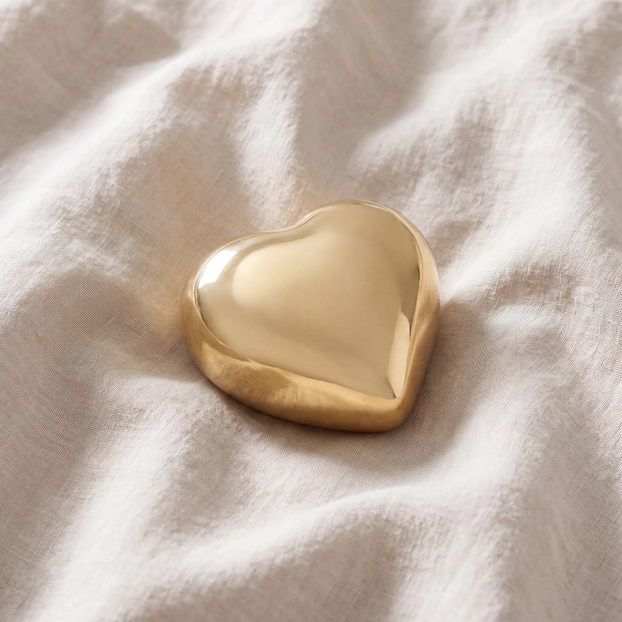 Heart-Keepsake-Urn-for-Ashes-in-Glossy-Gold-Metal-On-Linen