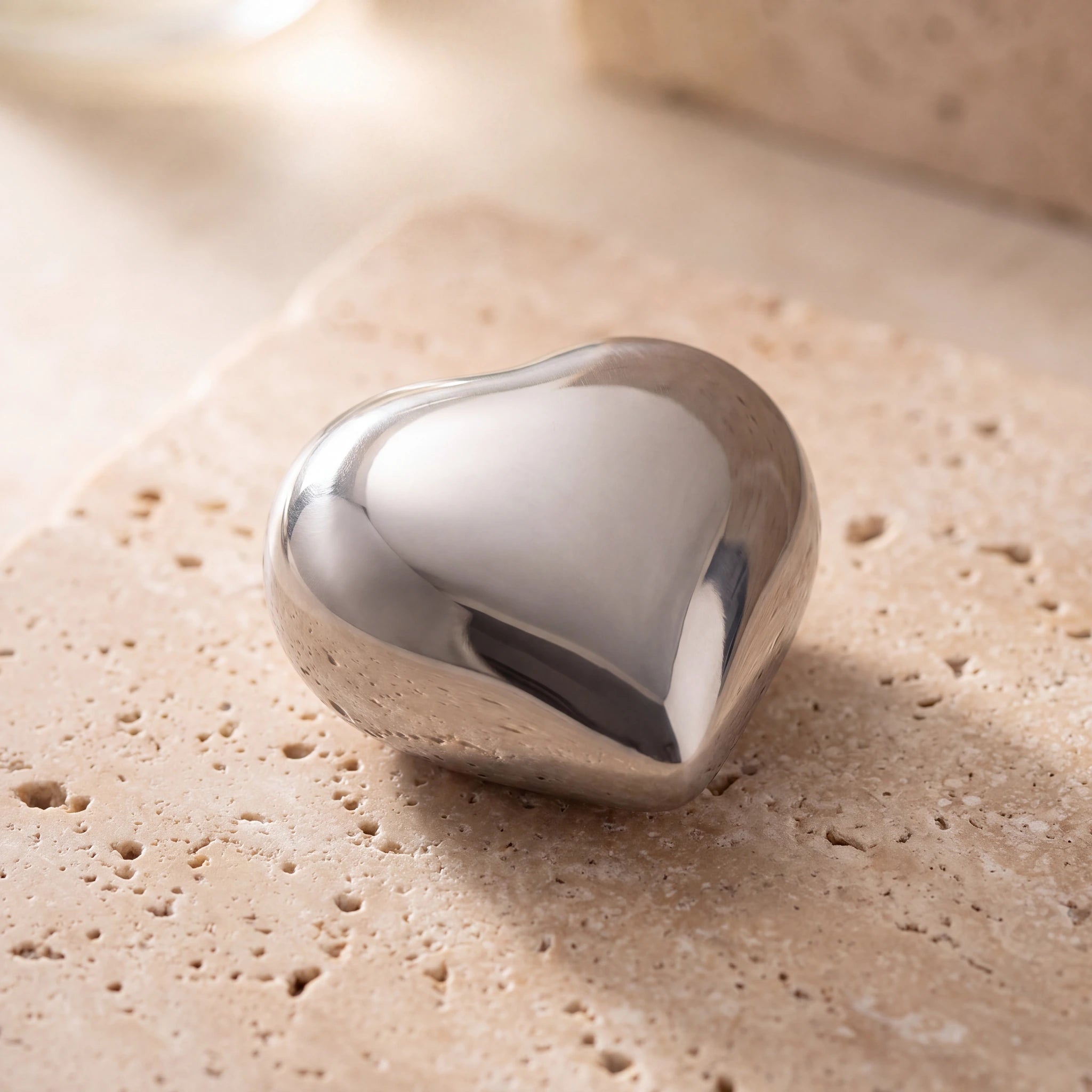 Heart-Keepsake-Urn-for-Ashes-in-Glossy-Silver-Metal-On-Travertine
