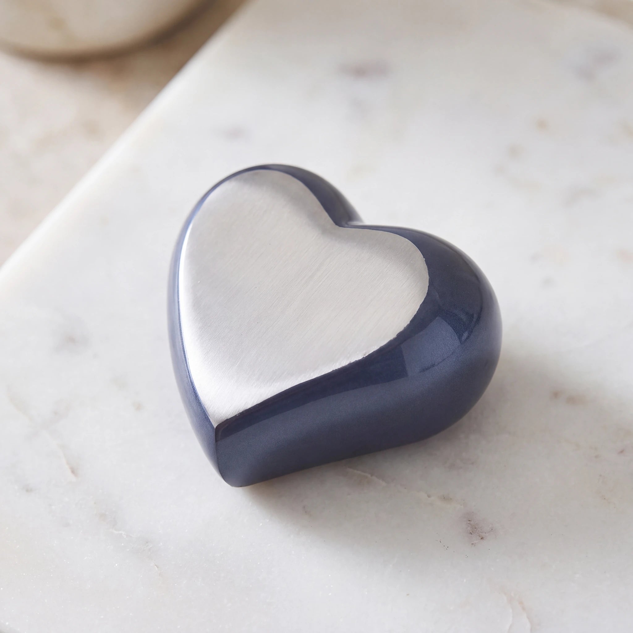 Heart-Keepsake-Urn-for-Ashes-in-Midnight-Blue-and-Silver-Metal-On-Marble