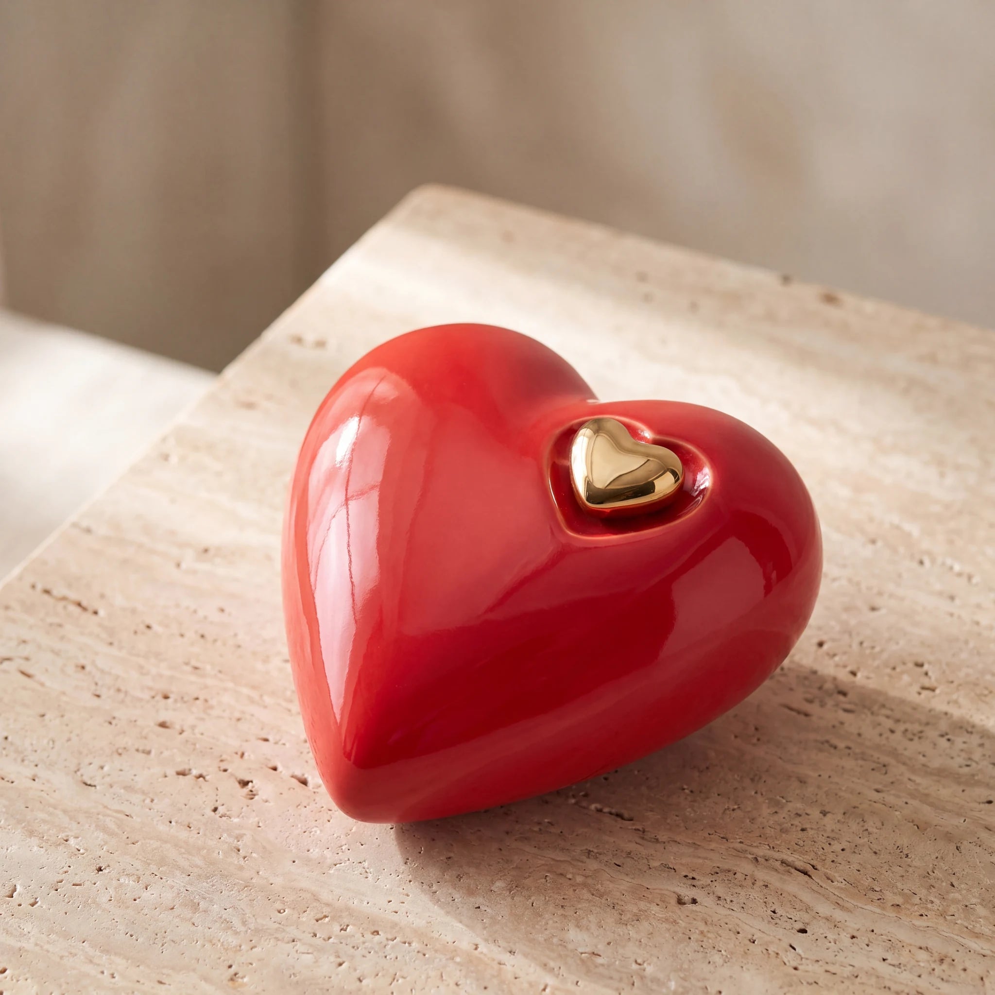Heart-Medium-Urn-for-Ashes-in-Red-and-Gold-On-Travertine