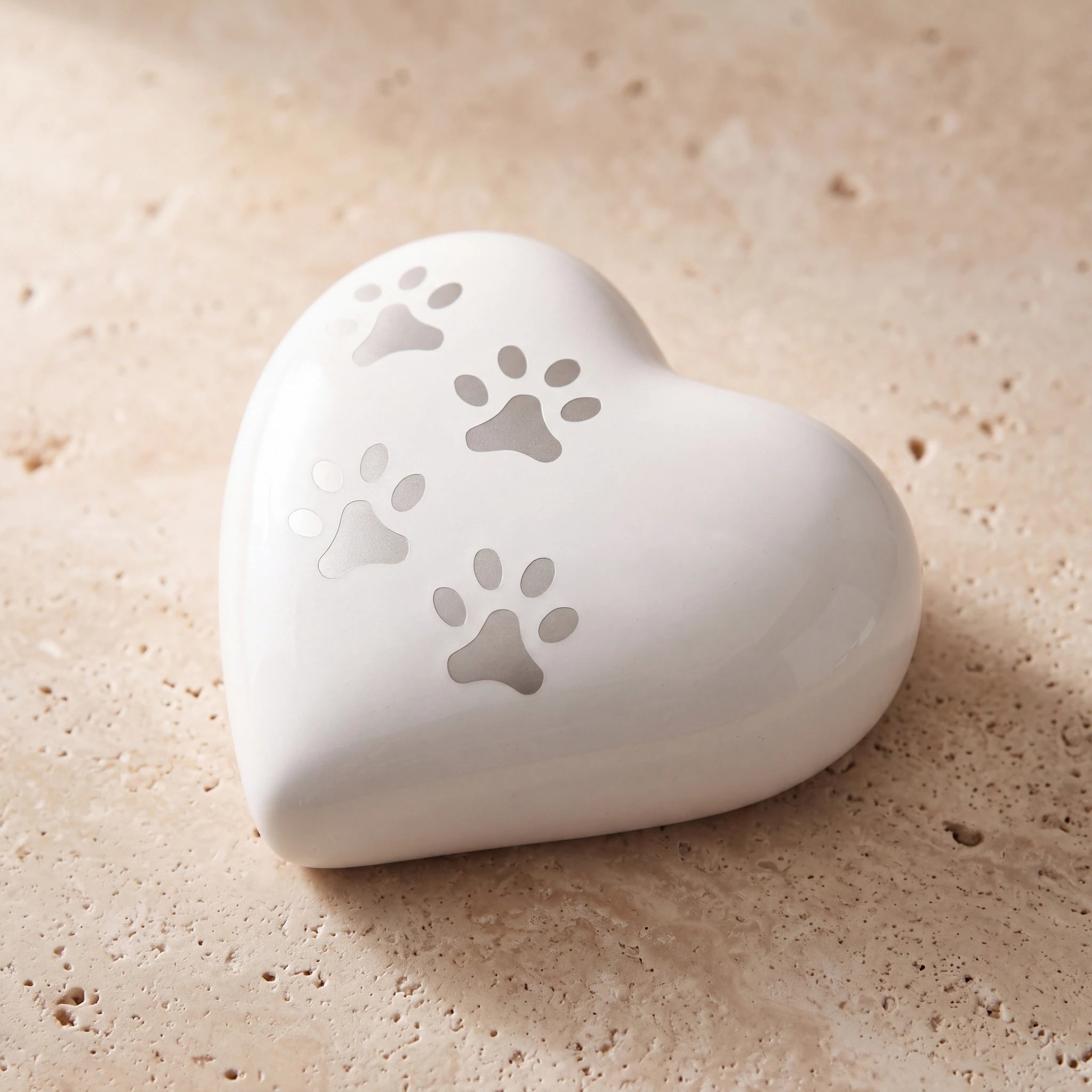Heart-Pawprints-Pet-Urn-for-Ashes-in-White-Silver-Keepsake-On-Travertine