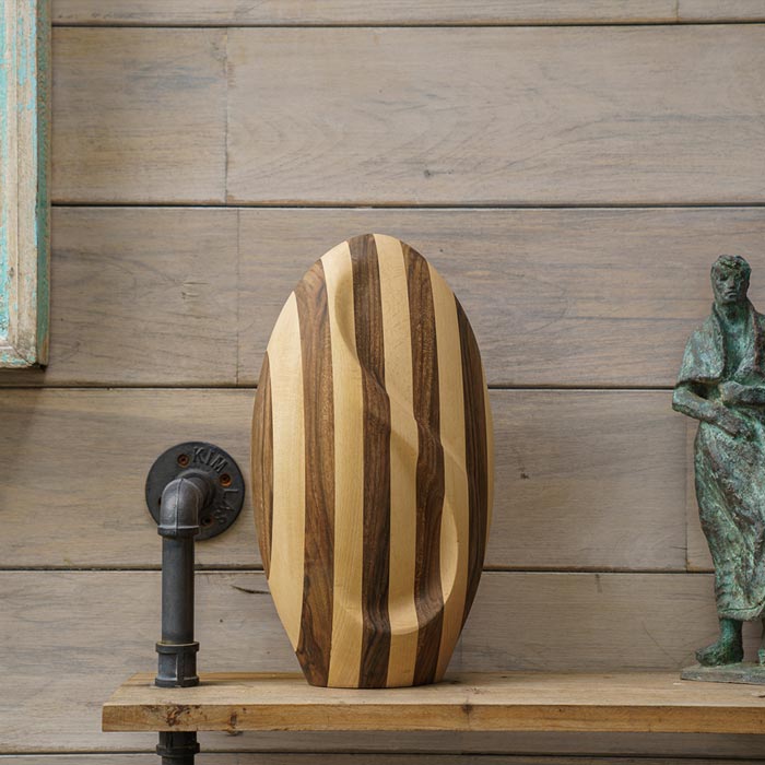 Infinity Wooden Adult Urn for Ashes Striped Walnut and Beech Wood on Table by Wall