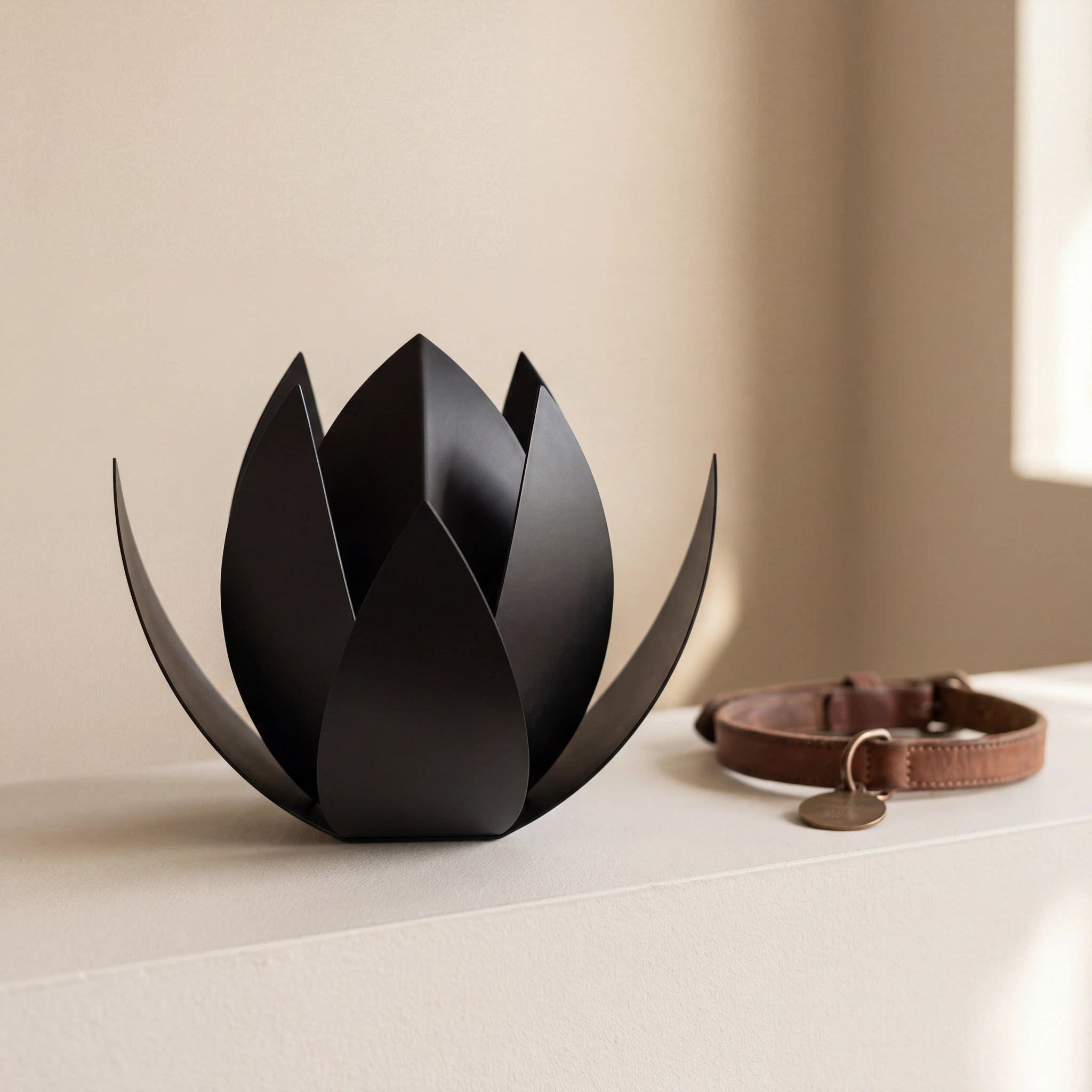 Lotus-Pet-Urn-for-Ashes-in-Matte-Black-Stainless-Steel-pet_collar_ledge