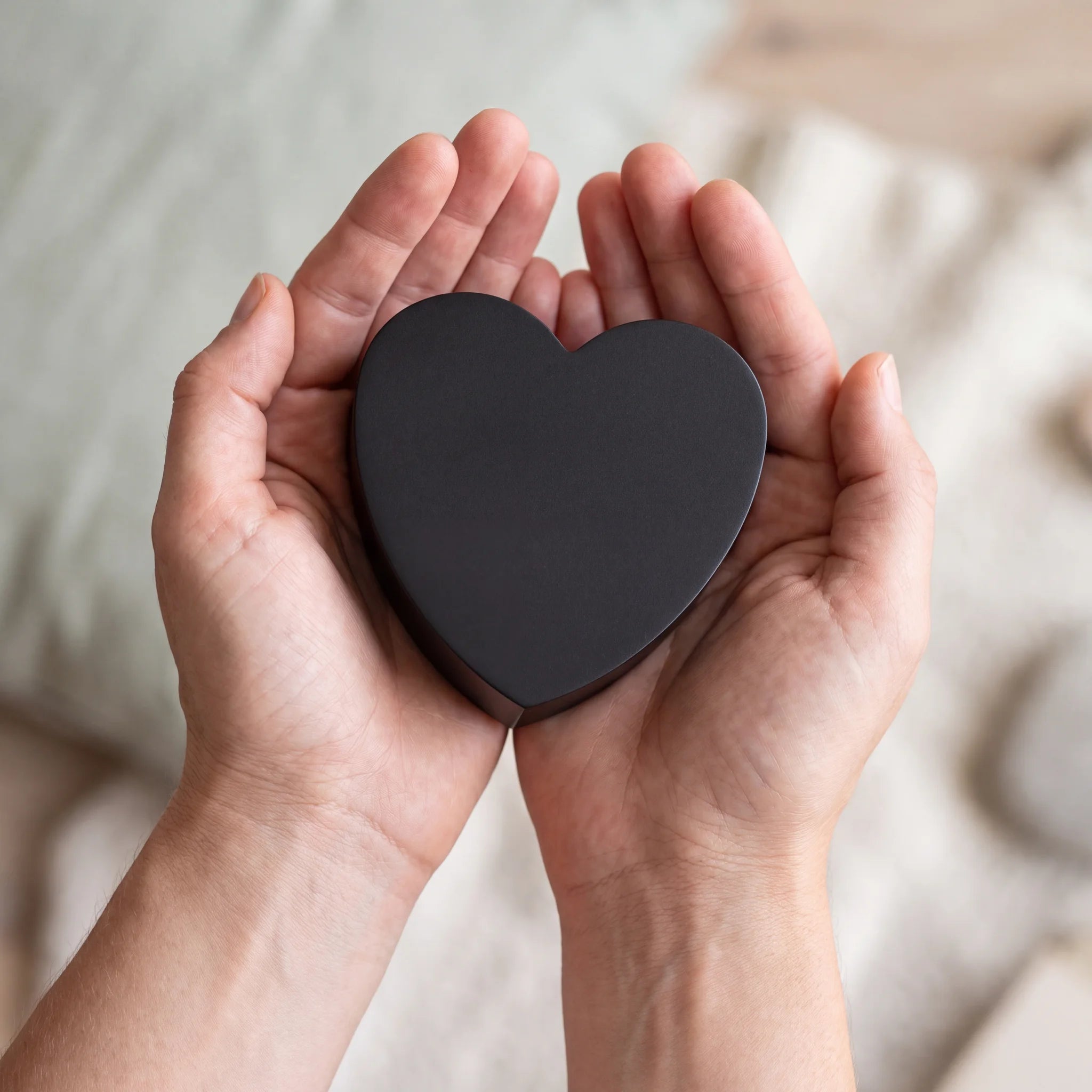 Love-Heart-Extra-Small-Urn-for-Ashes-in-Matte-Black-Stainless-Steel-Cupped-in-Hands