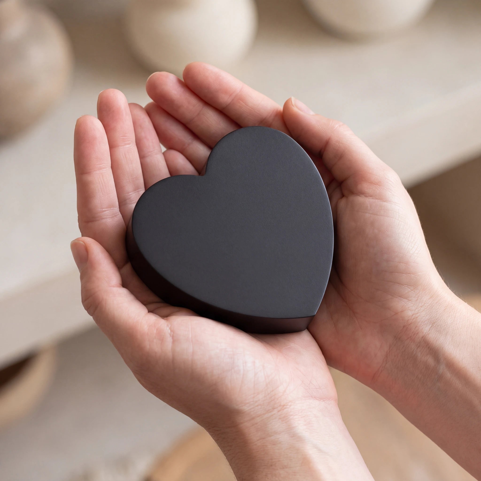Love-Heart-Small-Urn-for-Ashes-in-Matte-Black-Stainless-Steel-Cupped-in-Hands