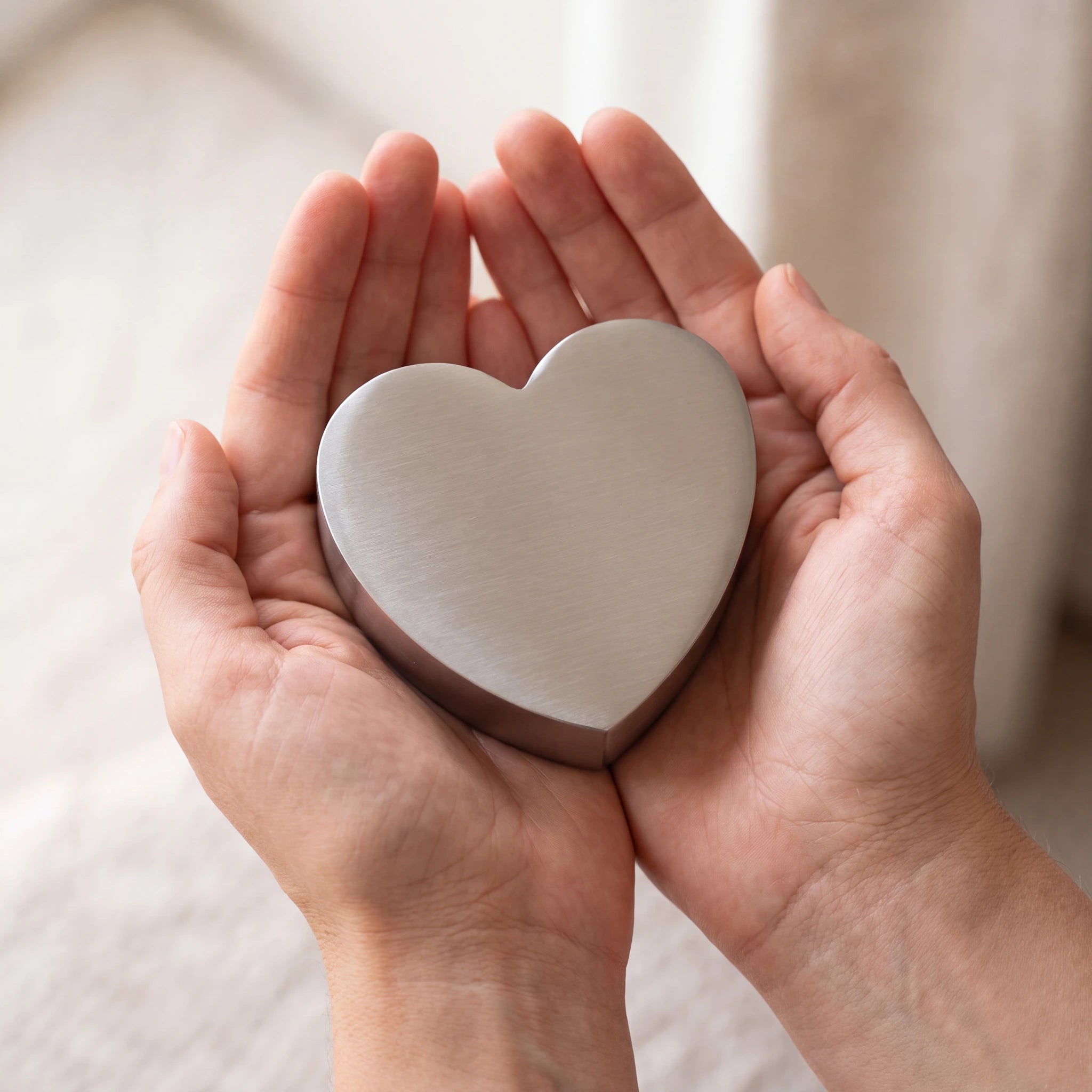 Love-Heart-Small-Urn-for-Ashes-in-Stainless-Steel-Cupped-in-Hands