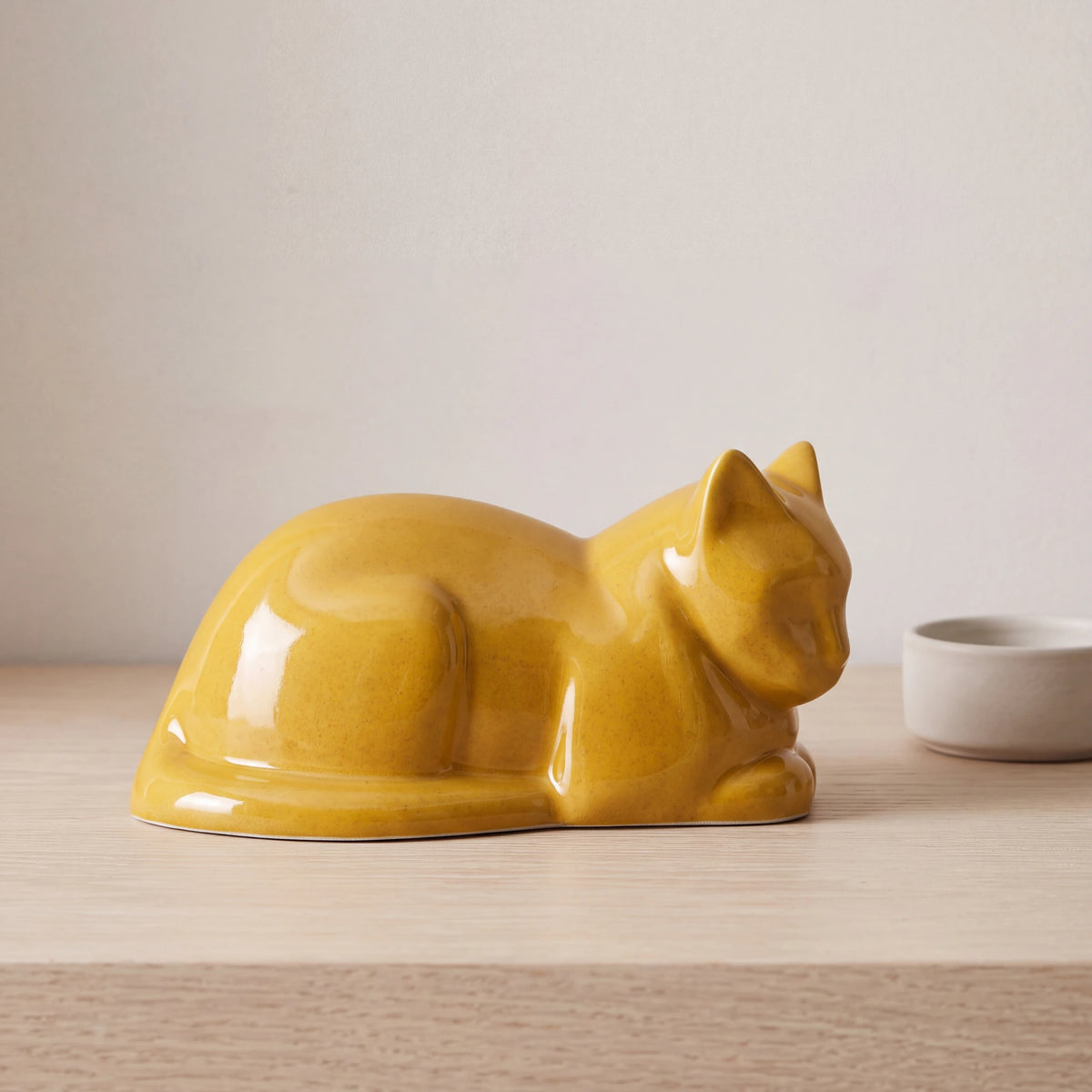 Lying-Cat-Urn-for-Ashes-in-Amber-Yellow-pet_bowl_ledge