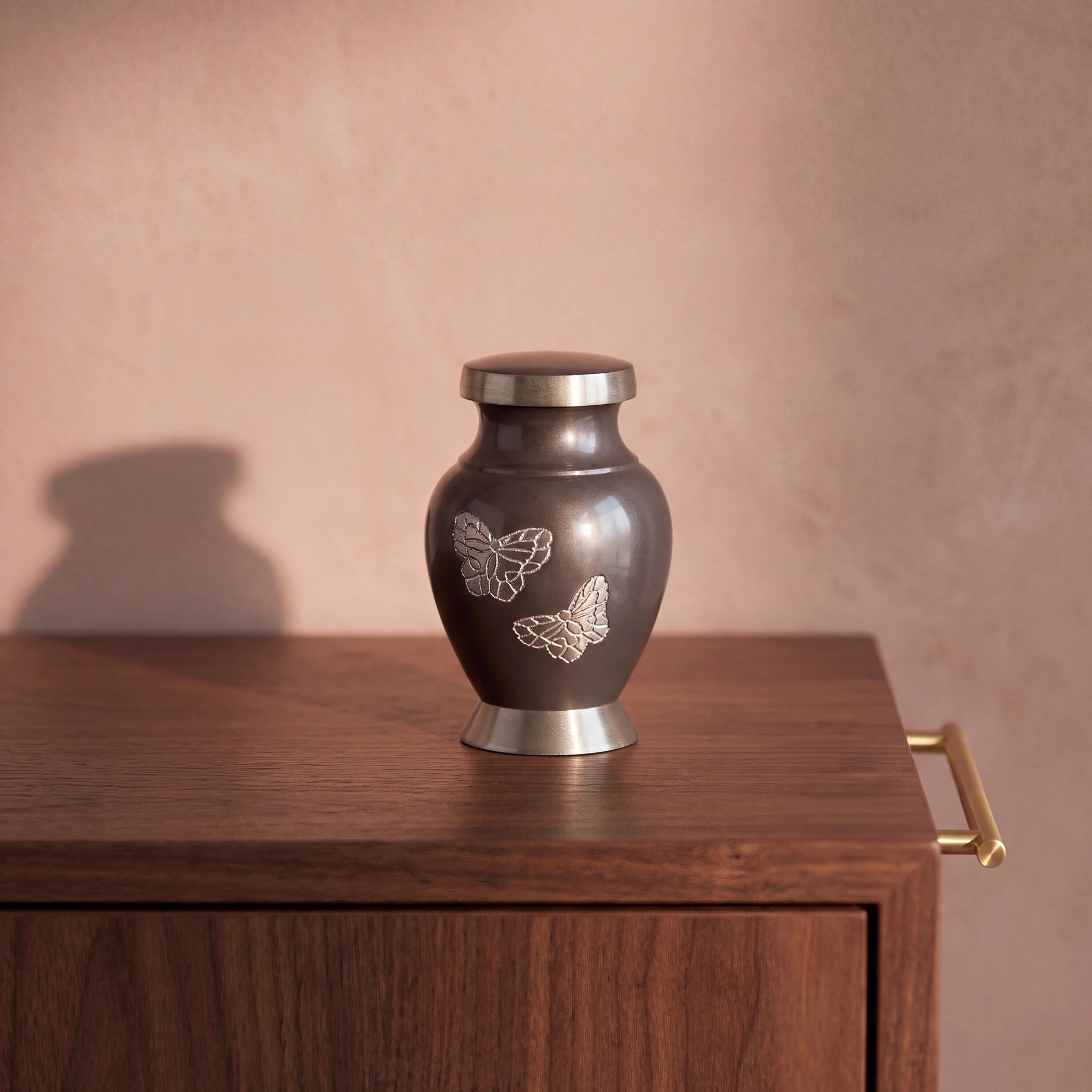 Metal-Butterfly-Keepsake-Urn-for-Ashes-in-Grey-with-Silver-Walnut-Sideboard